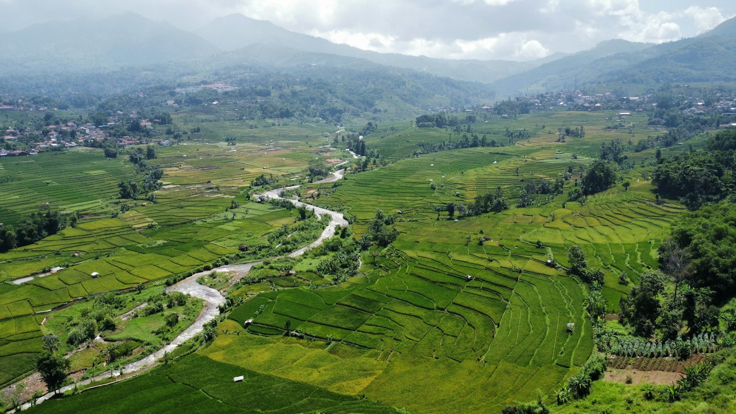Terraced rice paddies and a river wind through a valley.